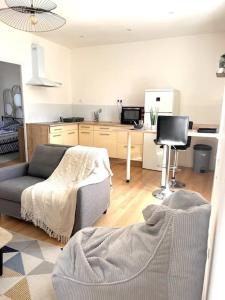 a living room with a couch and a kitchen at Appartement calme , 400m de la gare in Saint-Brieuc +4 photos