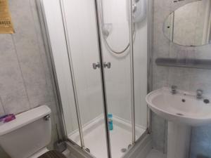 a bathroom with a shower and a toilet and a sink at The Celtic Pride Hotel in Blackpool