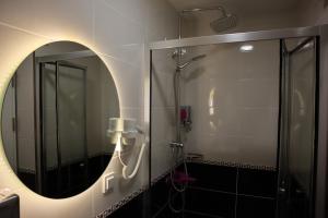 y baño con ducha y espejo redondo. en Galata istanbul Hotel, en Estambul