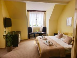 a hotel room with a bed and a window at Hotel Lužná in Luhačovice
