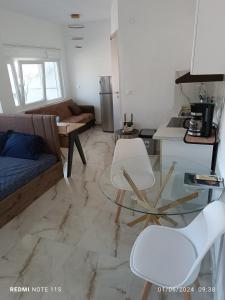 a living room with a glass table and white chairs at Zara's Boutique near Venizelos metro station in Thessaloniki