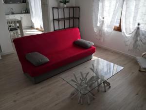 a red couch in a living room with a glass table at Appartamento da Guido in Borso del Grappa
