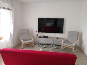 a living room with a red couch and two chairs at Appartamento da Guido in Borso del Grappa