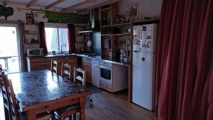 eine Küche mit einem Tisch und einem weißen Kühlschrank in der Unterkunft Gîtes de Revirand in Sarras + 32 Fotos