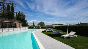 una piscina con 2 tumbonas y una sombrilla en Cappuccina Country Resort en San Gimignano