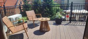 a patio with two chairs and a table on a balcony at Kapka wina in Toruń