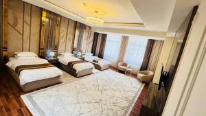 um quarto de hotel com duas camas e uma televisão em KANGURT Grand Hotel em Dushanbe