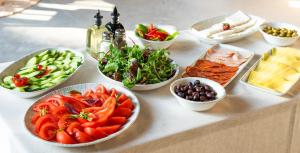 une table recouverte de bols de différents types de denrées alimentaires dans l'établissement Hotel Campus 90 - Free Parking, à Varna