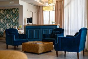a living room with blue chairs and a table at Cappuccina Country Resort in San Gimignano