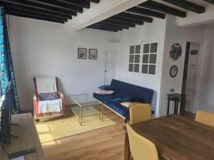 Una sala de estar con un sofá azul y una mesa. en le cosy Dieppe, en Dieppe