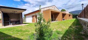 a house with a green yard next to a building at Las Casitas de Cueva in Cueva