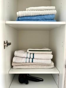- un placard avec des serviettes blanches et des serviettes bleues et blanches dans l'établissement Vacances bord de mer - Appartement Sanary sur Mer, à Sanary-sur-Mer