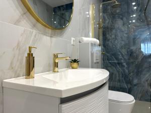 a white bathroom with a sink and a shower at Villa Apartment Danny in Baška Voda