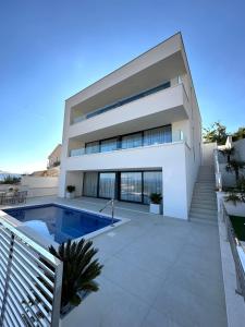 una casa con una piscina di fronte di Villa Apartment Danny a Baška Voda