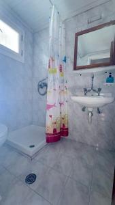 bagno con tenda per la doccia e lavandino di Dionysos Studios a Laganas