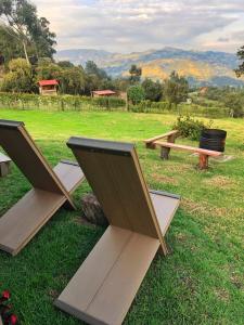 a group of picnic tables sitting on the grass at Refugio Aventura, romántico glamping montañero in Tabio