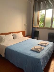een slaapkamer met een bed met twee handdoeken erop bij Hotel Mercurio in Milaan