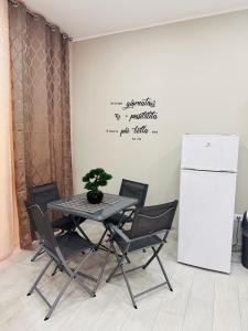 un tavolo con sedie in una stanza con frigorifero di Horus Home a Torre del Greco