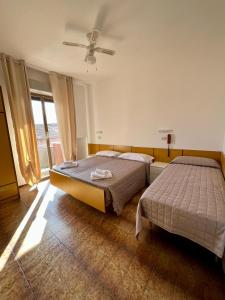 1 dormitorio con 2 camas y ventana en VILLA DEI FIORI, en Bellaria-Igea Marina