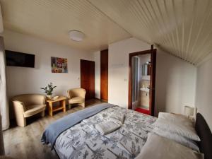 Schlafzimmer mit einem Bett, einem Tisch und Stühlen in der Unterkunft Balaton Panzió Füred in Balatonfüred