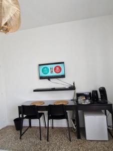 a desk with chairs and a computer monitor on a wall at Chambre Sommières in Sommières
