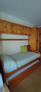 uma cama num quarto com armários de madeira em San Isidro EL LLAR 122 em San Isidro