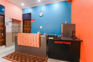 recepcja w pokoju z niebieską ścianą w obiekcie OYO Hotel Flight View w mieście Dżajpur