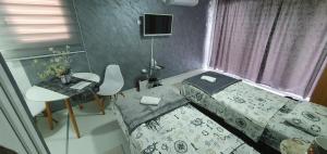Dormitorio pequeño con cama y mesa en Cozzy apartment near the Aiport Podgorica en Podgorica