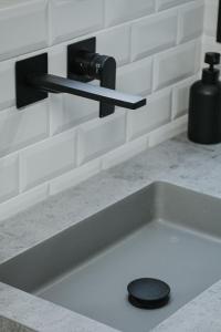 a kitchen sink with a black faucet and a drain at La Casa del Conde - Un alojamiento único en Écija in Écija +43 photos