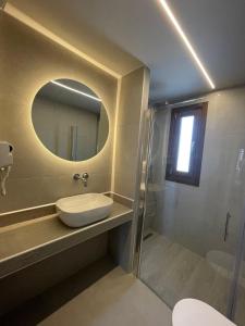 a bathroom with a sink and a mirror at Αura Luxury Apartments in Ierissos
