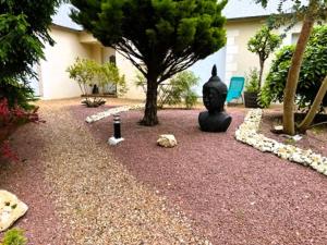 un jardín con una estatua en medio de un patio en LA ROMANTIQUE SPA, en Saint-Avertin