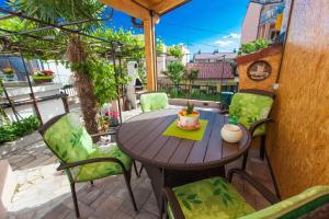 a wooden table and chairs on a patio at Ferienhaus für 4 Personen ca 62 qm in Crikvenica, Kvarner Bucht Crikvenica und Umgebung in Crikvenica +14 photos