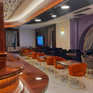 Habitación con mesas, sillas y TV. en KANGURT Grand Hotel en Dushanbe