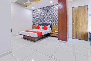 a bedroom with a bed with red pillows on it at Hotel Shiv Inn in Vadodara