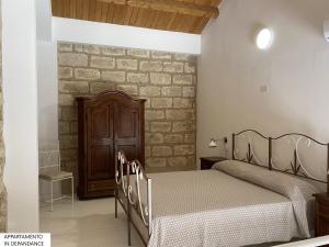 1 dormitorio con 2 camas y pared de ladrillo en Tenute Plaia Agriturismo en Scopello