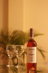 - une bouteille de vin à côté de deux verres à vin dans l'établissement Hostal The Princess, à Chaclacayo