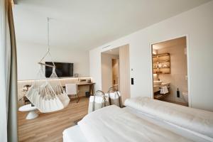 biała sypialnia z łóżkiem huśtawkowym i biurkiem w obiekcie Nouri w mieście Bad Krozingen