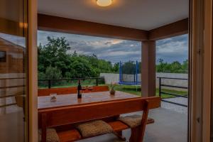 un porche con mesa y 2 copas de vino en Villa Stocozzi, en Štokovci