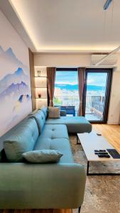 a living room with two blue couches and a large window at Diamond Residences 10th fl. Lux Apt. w/ City view in Skopje +27 photos