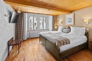 ein Schlafzimmer mit einem großen Bett und einem TV in der Unterkunft Le Saint Georges in Gruyères