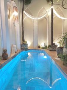 a blue swimming pool in a room with plants at Nguyễn Villa Royale in La Gi