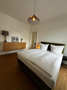 1 dormitorio con 1 cama blanca grande con lámpara en Exklusives Apartment im Herzen Saarbrückens, en Saarbrücken