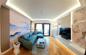 a living room with a blue couch and a tv at Diamond Residences 10th fl. Lux Apt. w/ City view in Skopje