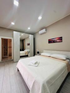 una camera da letto con un grande letto bianco e uno specchio di Horus Home a Torre del Greco