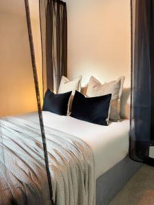 Una cama con almohadas blancas y negras. en Scandinavian Haus For 8 en Mánchester