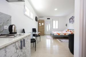 a room with a kitchen and a bedroom with a bed at Harmonija in Palić