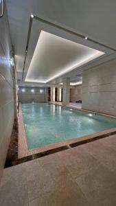 - une grande piscine dans un bâtiment dans l'établissement KANGURT Grand Hotel, à Douchanbé