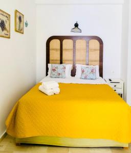 una camera da letto con un letto giallo e asciugamani di Gerani Studios a Astypalaia Town