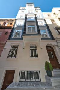 un edificio alto de color blanco con ventanas y una maceta en Dizayn Apart Otel, en Estambul