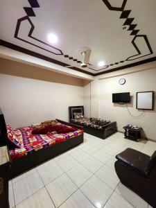 a room with two beds and a flat screen tv at Hotel New Taj International in Rawalpindi